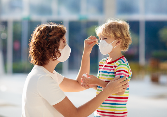 Parent putting mask on for child