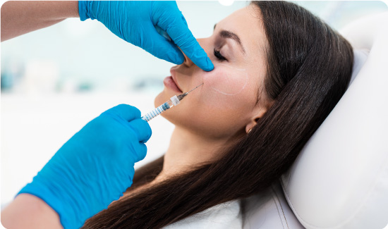 Beautician is contouring the woman's cheekbones with filler.