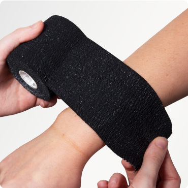 Black Tear Lite Elastic Adhesive Bandage being applied to someones arm