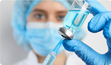 Doctor filling syringe with medication, closeup