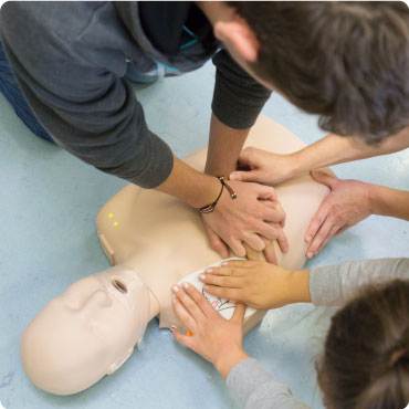 People using a training defibrillator on a manikin