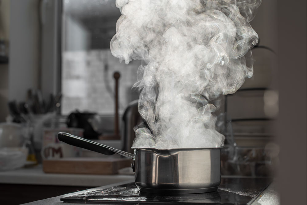 Cooking Pot filles with boiling water steaming on a hob