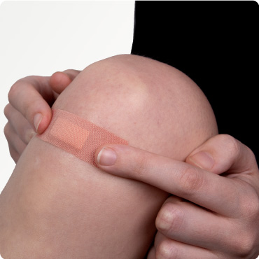 Fabric plaster being applied to a knee