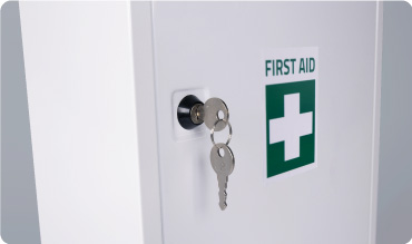 Metal First Aid Cabinet closeup with key in the door