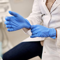 A doctor putting medical gloves on
