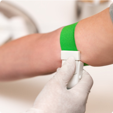 Patient with a green tourniquet band on their arm