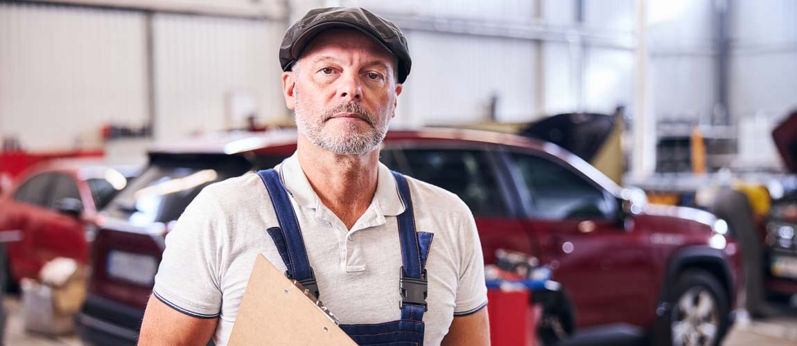 auto mechanic holding clipboard for risk assessment