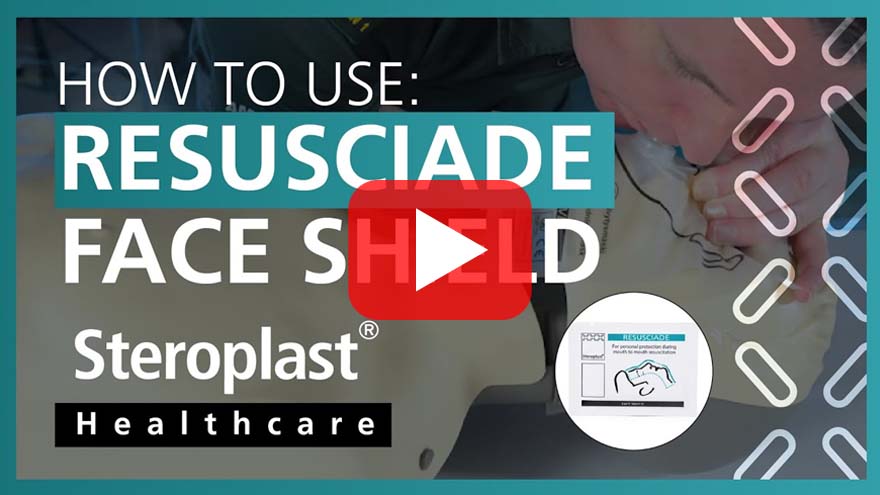 Video thumbnail showing a person demonstrating mouth-to-mouth resuscitation on a mannequin with a Resusciade face shield. Text reads 'How to Use: Resusciade Face Shield' with the Steroplast Healthcare logo beneath. An illustration of the face shield appears in the lower right corner, and a play button is centred on the image.