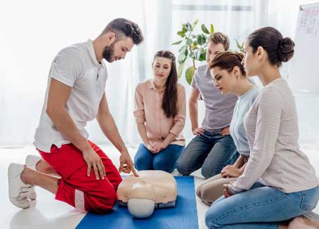 instructor gesturing during first aid training with group of people