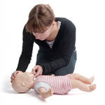 Woman practising CPR on a baby CPR training manikin