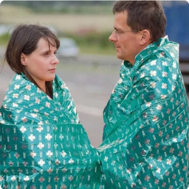Man and woman stood at the side of the motorway with mediwrap protection blanket on