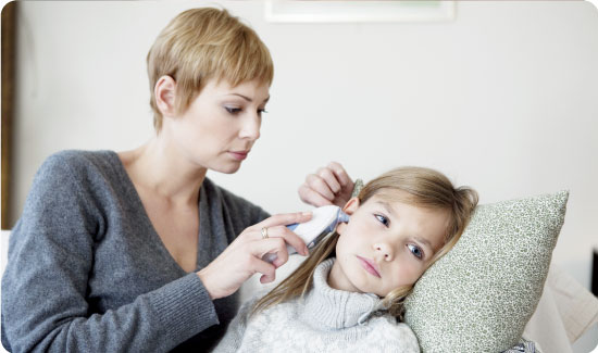 Mother using ear thermometer at home