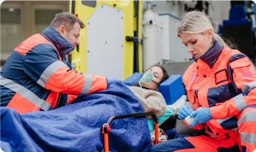 Paramedics tending to a patient in a guerney outside of an ambulance
