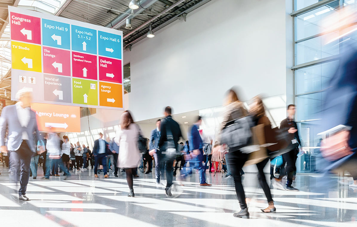 People walking around a trade show entrance hall