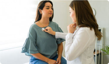 Doctor using a stethoscope to listen to a patients chest