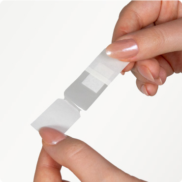 Someone peeling back a sensitive plaster ready for application