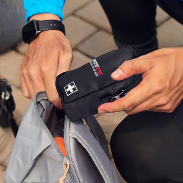 Cyclist packing sports first aid kit into backpack