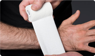 Steroplast Tear Lite Elastic Adhesive Bandage being applied to someones wrist