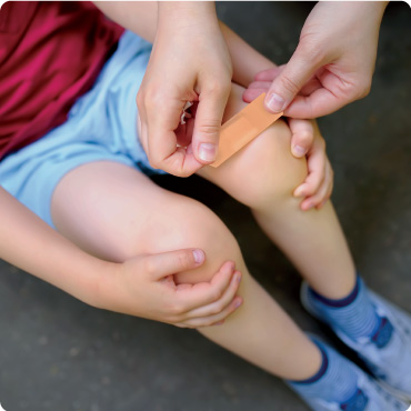 Washproof plaster being applied to a childs knee