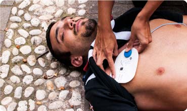 Woman putting defib pads on man