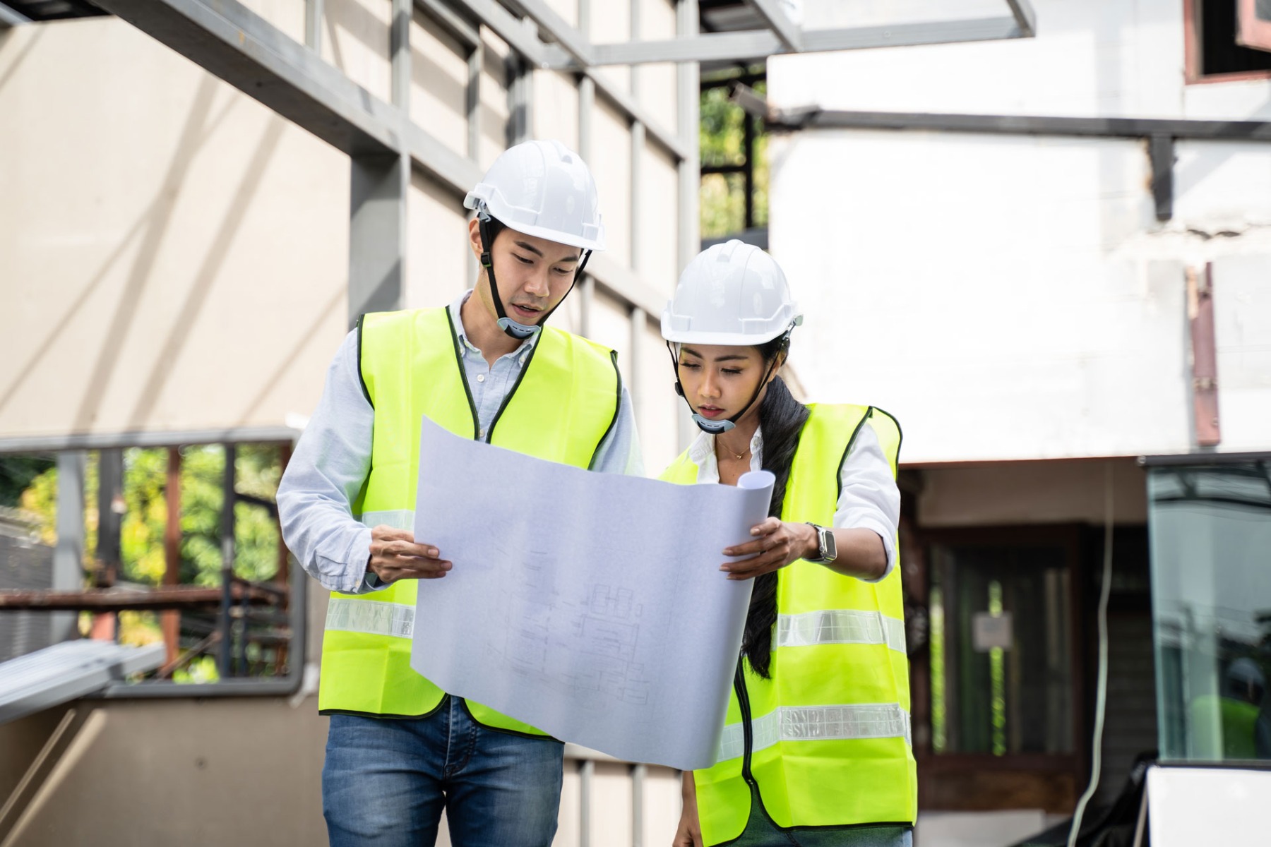 Colleague workers holding drawing working on construction side discussing about project