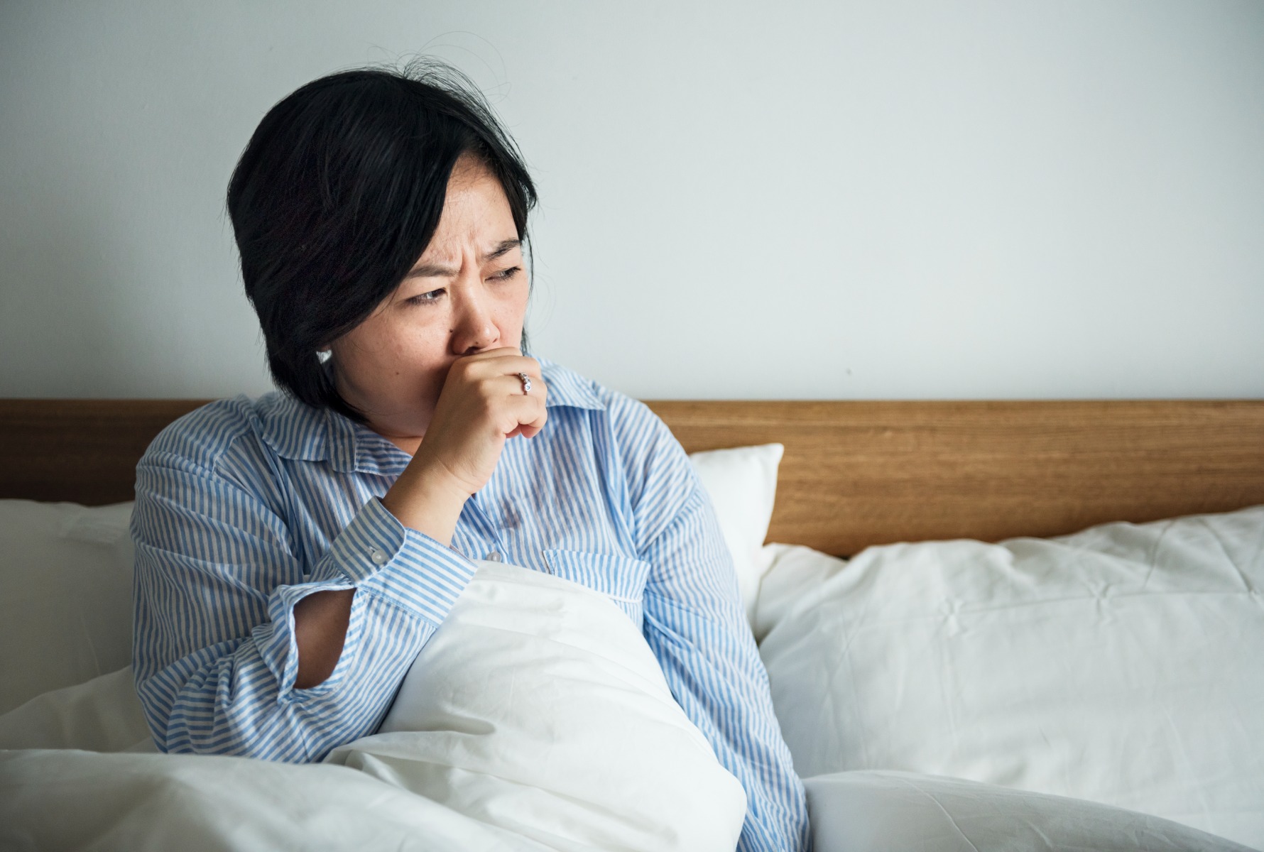 A woman coughing in domestic setting