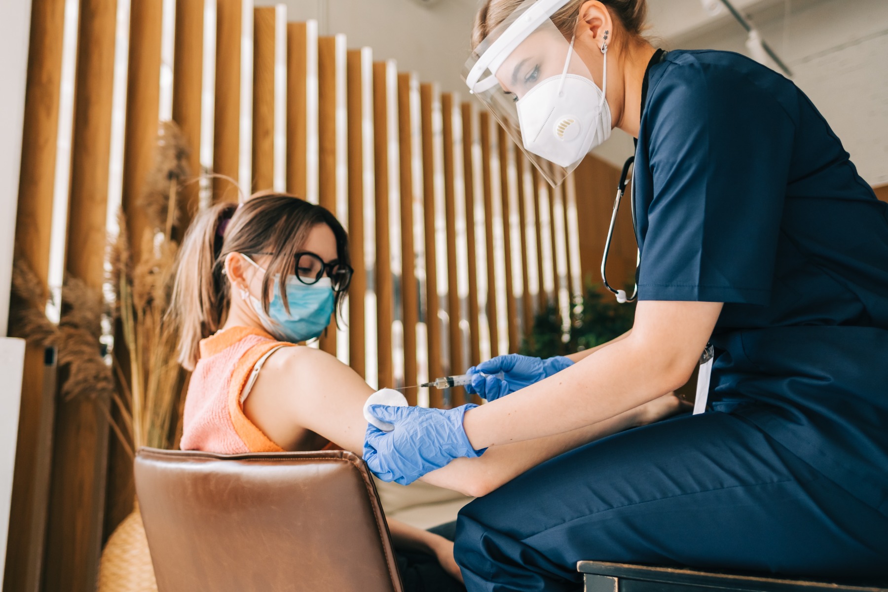 hospital patient receiving treatment from a staff member wearing PPE