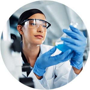 Female scientist examining a beaker of blue liquid in a laboratory