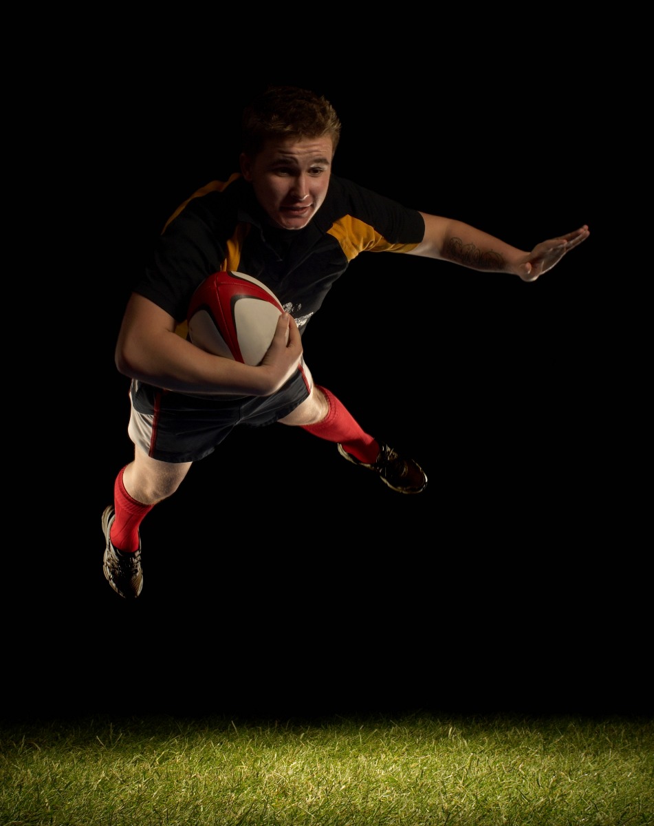 Rugby player mid air with ball