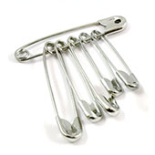 Set of silver safety pins in varying sizes, grouped on a large pin for convenience